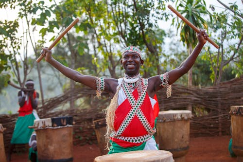 Happy People Playing Drums in Traditional Tribal Clothing 