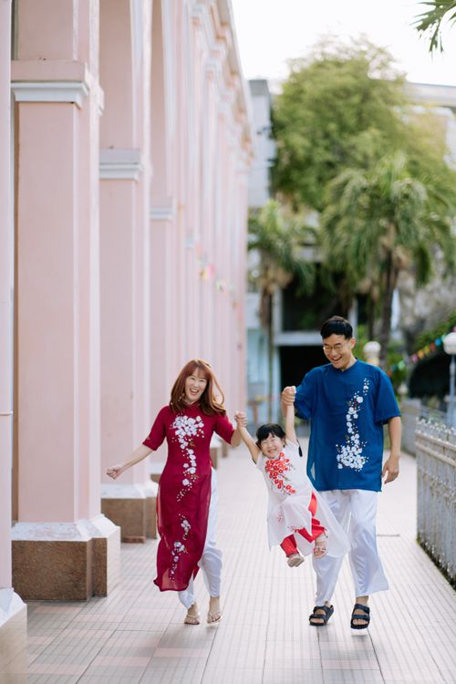 Free Happy family wearing traditional clothing, enjoying a walk on an urban sidewalk. Stock Photo