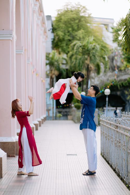 Free A family enjoys a playful moment outdoors in a vibrant city setting. Stock Photo