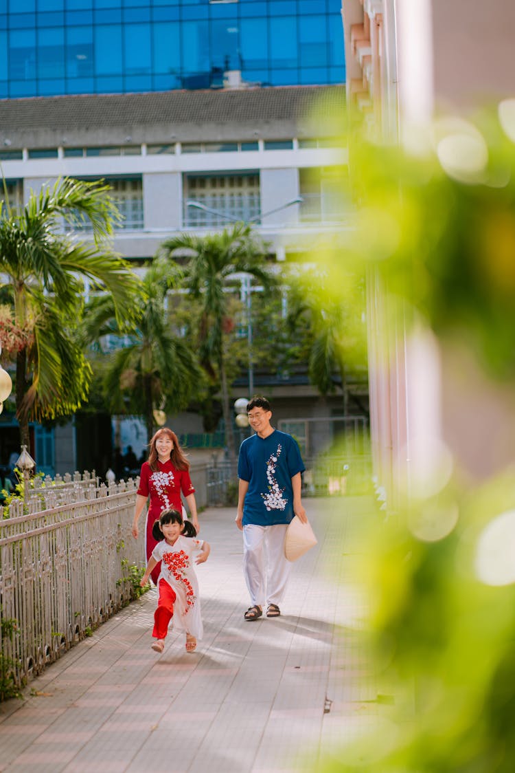 A Kid Running Ahead Of Her Parents