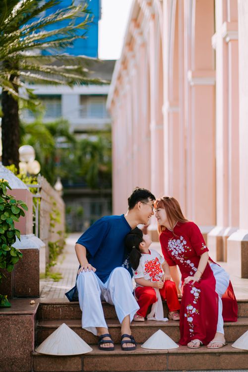 Free A loving family portrait featuring parents and child in traditional attire on sunny day outdoors. Stock Photo