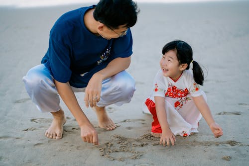 A Girl and Her Father Playing with Sand