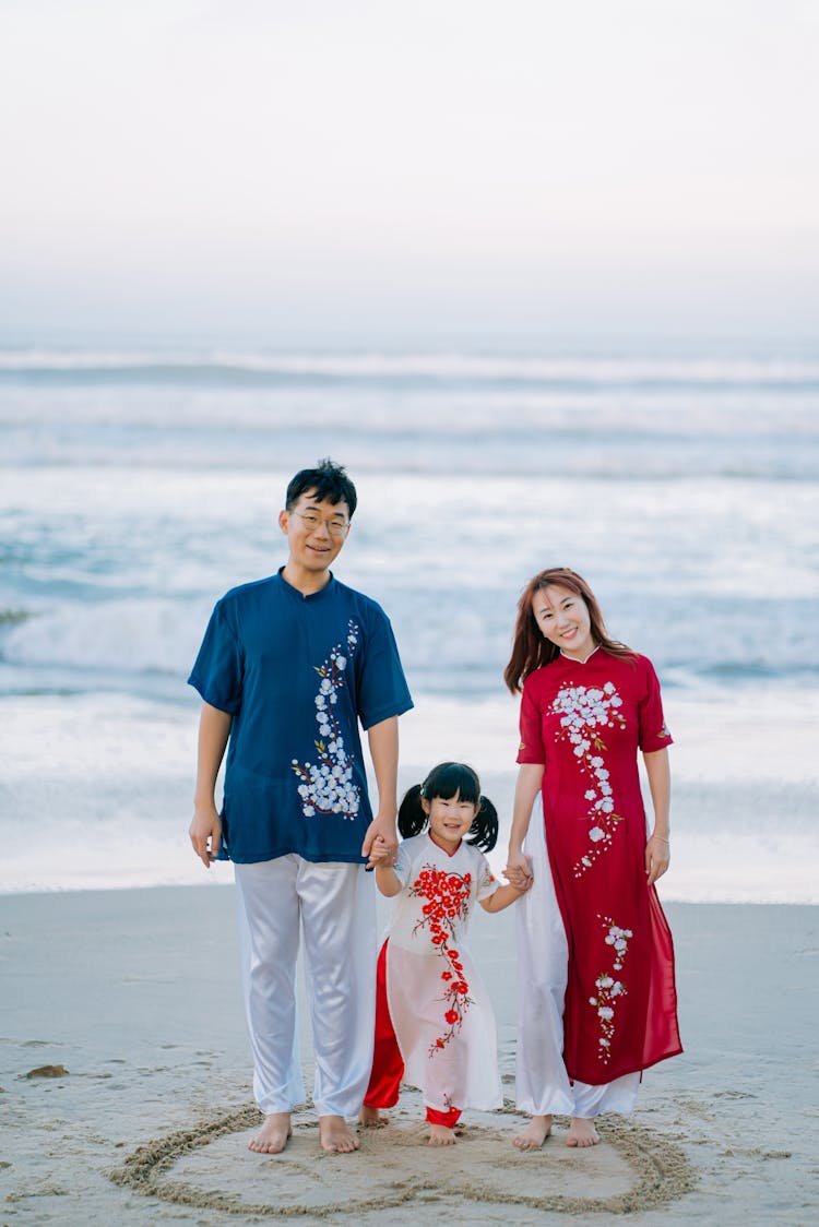 A Family Holding Hands At A Beach