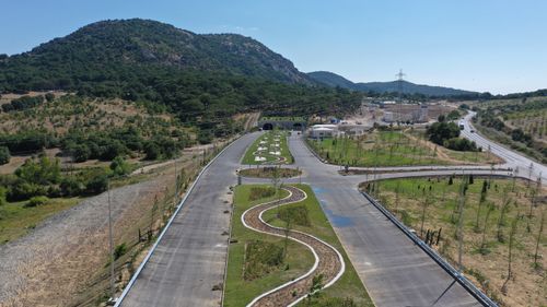 Free Aerial view of a curvy road in Yeniçam, Çanakkale with lush mountains and clear skies. Stock Photo