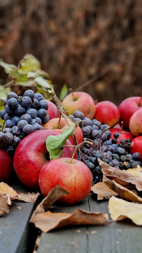 Apples and Purple Grapes on the Wooden Table 