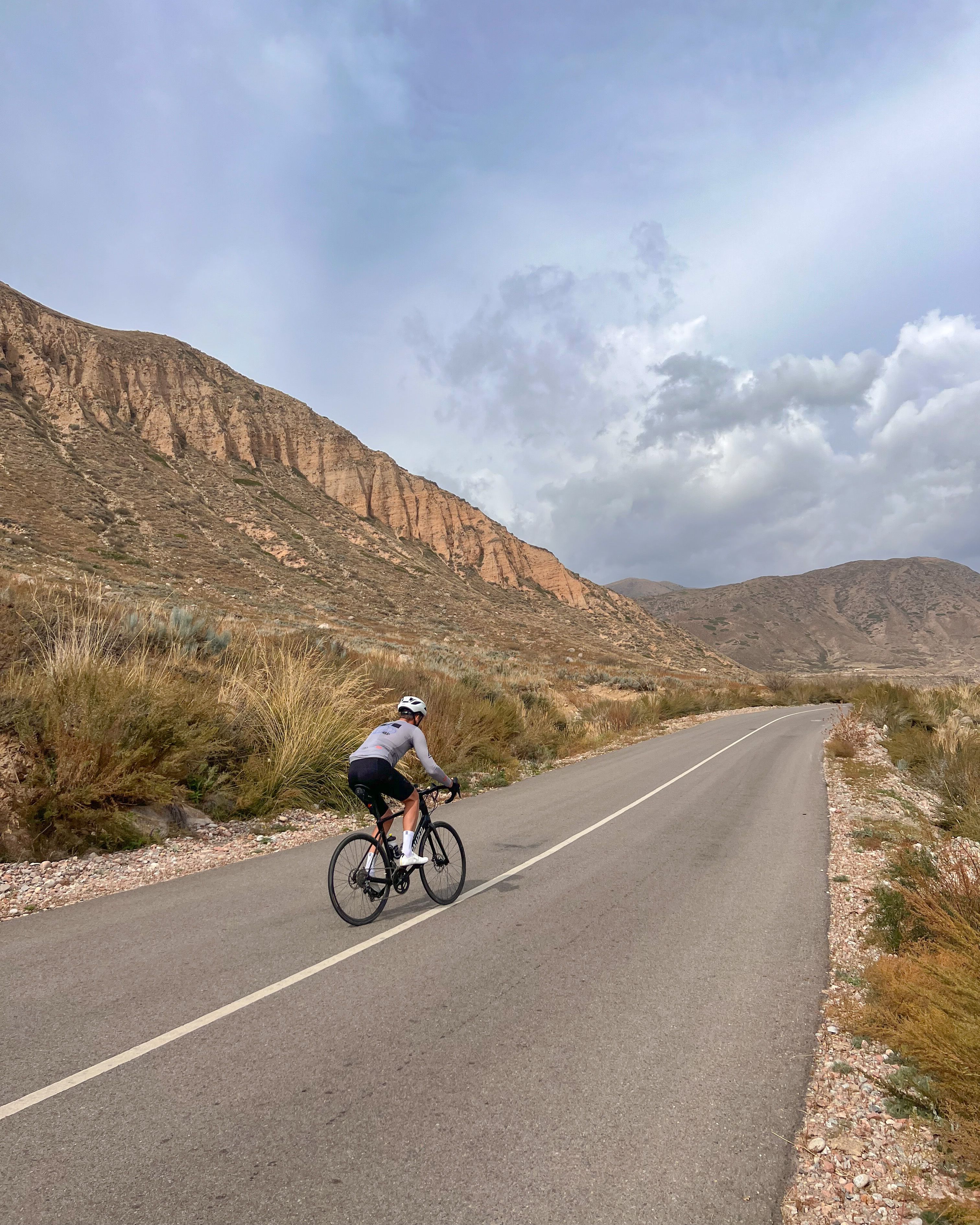 A Person Riding Bicycle on Road Near Hill · Free Stock Photo