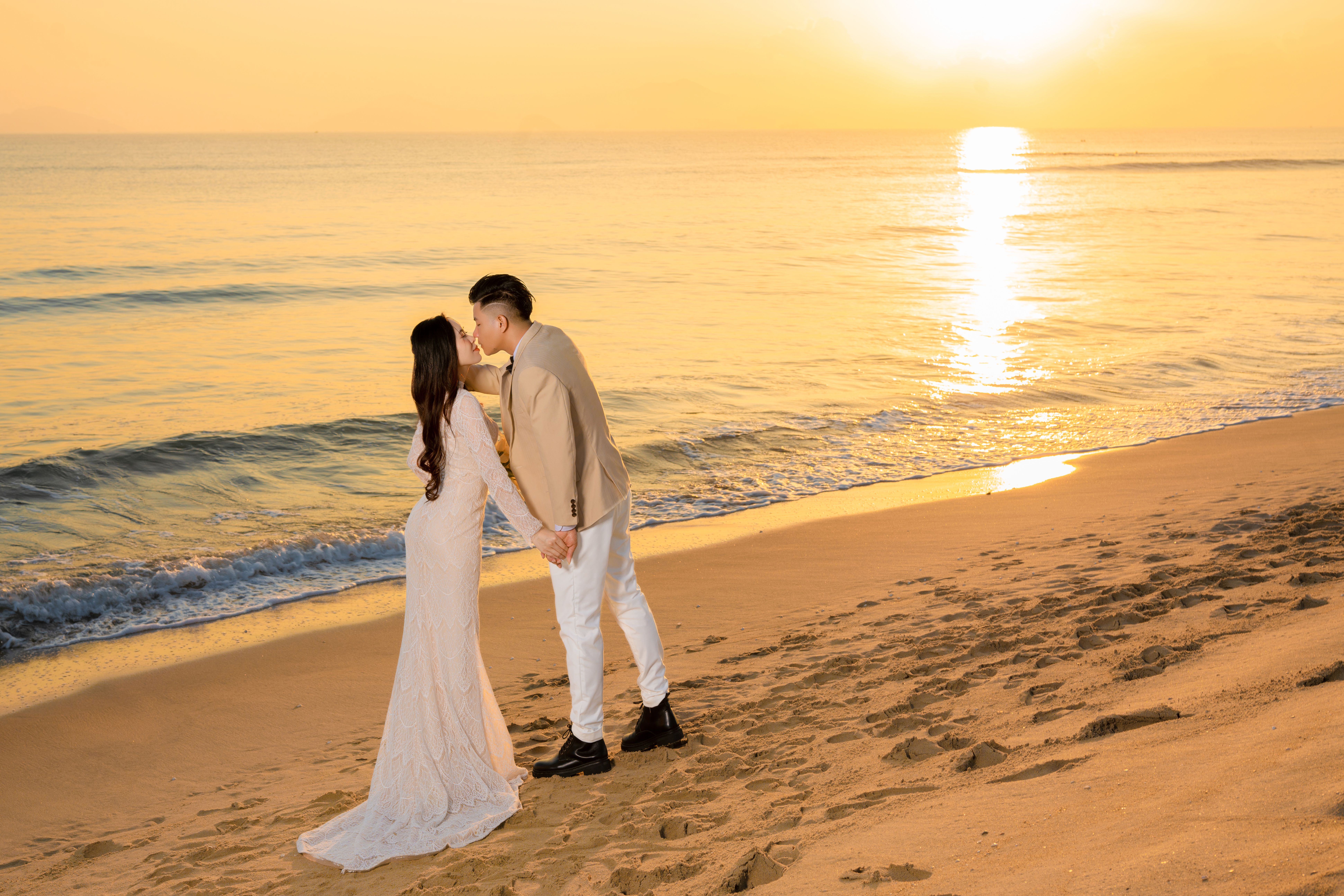 A Bride and a Groom Kissing at the Beach · Free Stock Photo