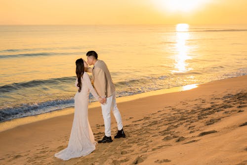 A Bride and a Groom Kissing at the Beach