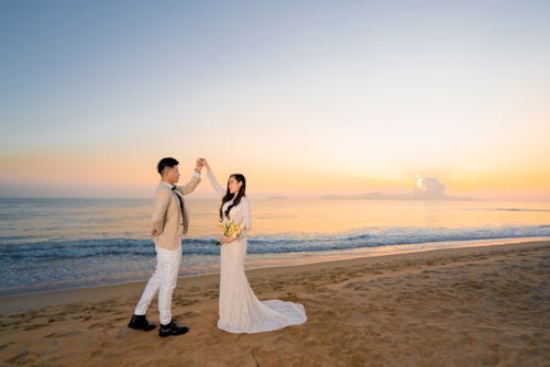 A Bride and a Groom Dancing at the Beach