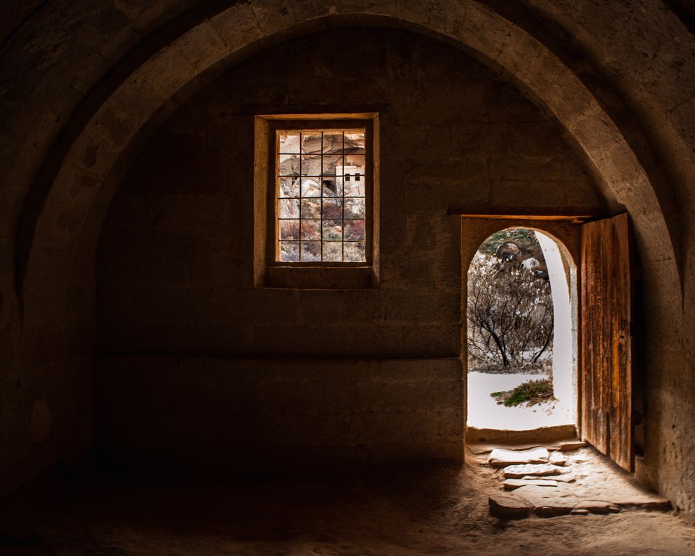 A heavy old door standing open to the light outside - The Open Door