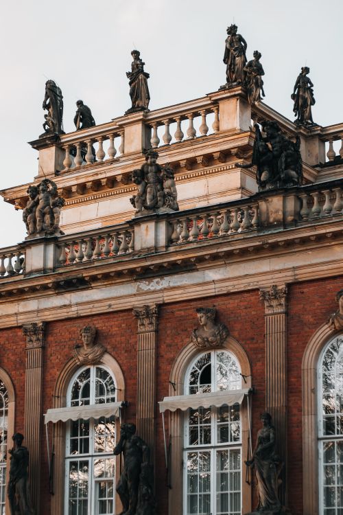 Free Historic baroque building facade adorned with detailed sculptures and statues in golden hour lighting. Stock Photo