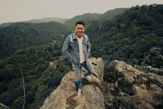 A Man in Denim Jacket Standing on the Rock