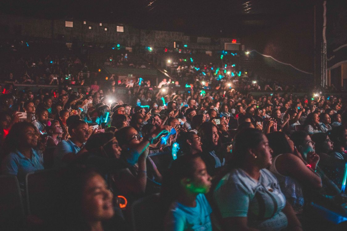 Free A vibrant audience enjoying a live music concert with colorful lights in a large venue. Stock Photo