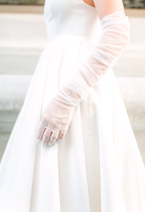 White Gloves of a Woman in White Dress