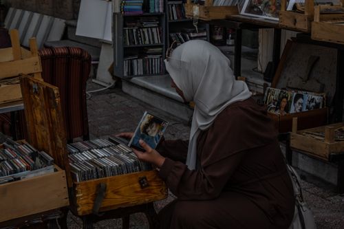 Free Woman shopping for vintage CDs at an outdoor market stall on Heybeliada, İstanbul, Türkiye. Stock Photo