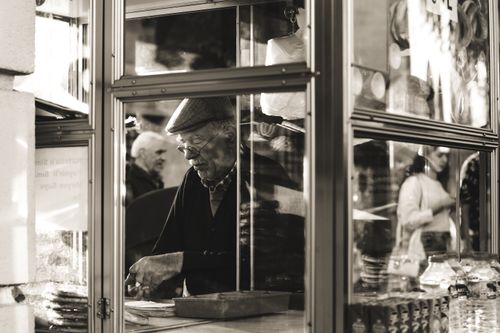 Free A timeless black and white image of a street vendor in an urban setting, captured candidly. Stock Photo