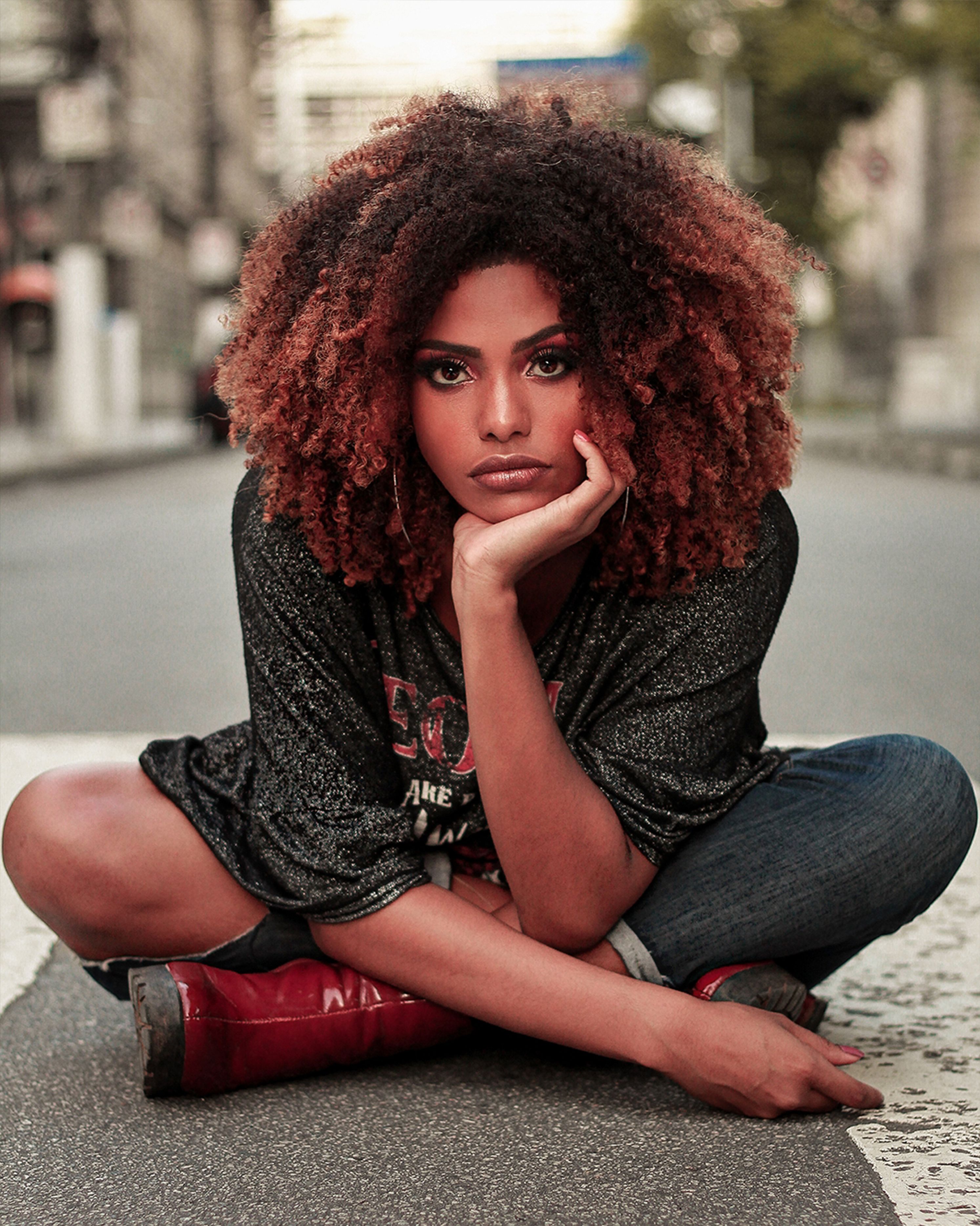 A Woman with Curly Hair Sitting on the Floor · Free Stock Photo