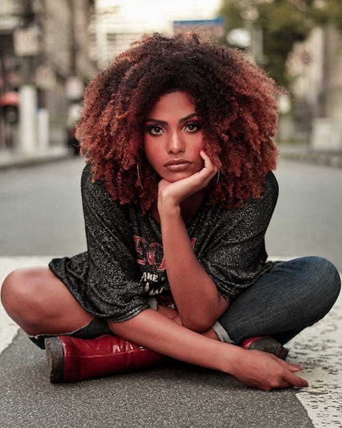 A Woman with Curly Hair Sitting on the Floor