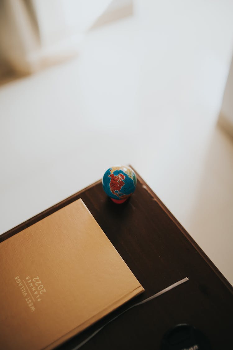 Small Globe At The Edge Of A Wooden Desk