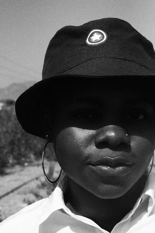 Grayscale Photo of a Woman Wearing Black Fitted Cap