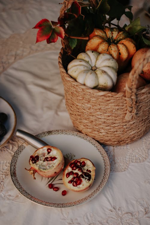 Pumpkins in Basket near Pomegranate on Plate