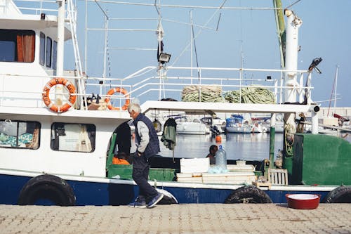 An Elderly Man Waking in the Harbor Docking Area