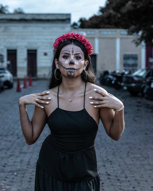 Woman in Black Spaghetti Strap Dress with Floral Headdress Wearing Skull Face Paint