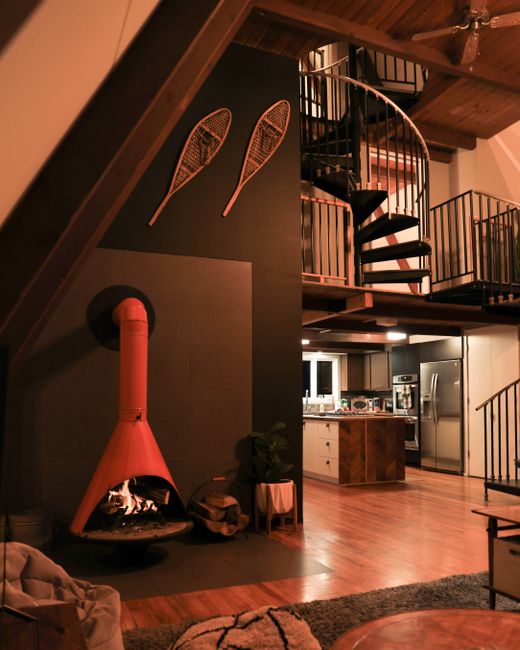 Warm interior with a spiral staircase and a stylish fireplace, perfect for relaxation.