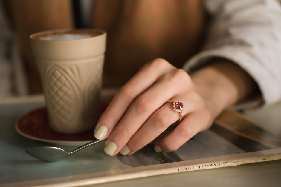 A red ruby ring in yellow gold worn on a finger, photographed in soft natural light, close up