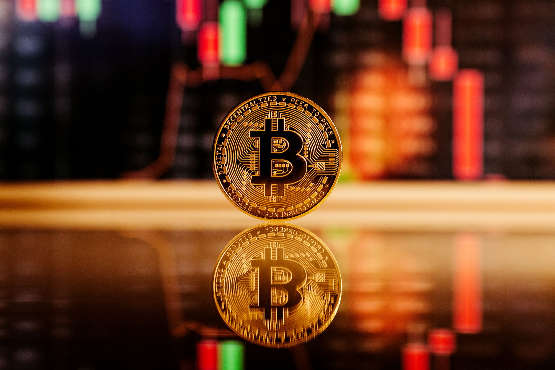 Close-up of a Bitcoin coin with a stock market chart background, symbolizing cryptocurrency trading.