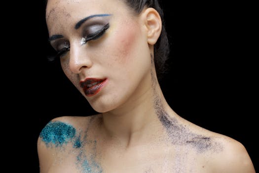 Artistic portrait featuring colorful glitter makeup on a woman's face against a dark background.
