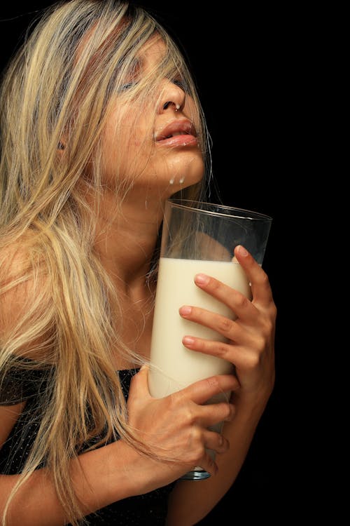 Фотография женщины, держащей стакан молока
