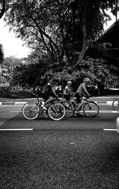 Monochrome Photography of People On Bicycle