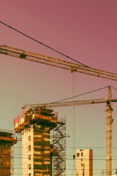 Vertical urban construction scene in Oslo featuring cranes and scaffolding.