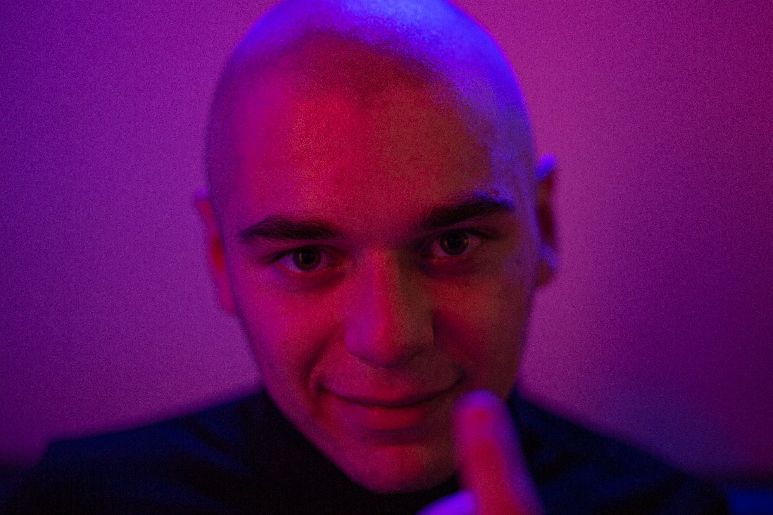 close-up-photo-of-bald-man-smiling-in-purple-background-free-stock-photo