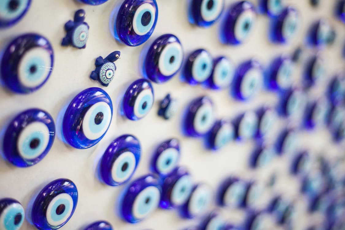 Selective Focus Photography of Round Blue Gemstone Lot on White Surface