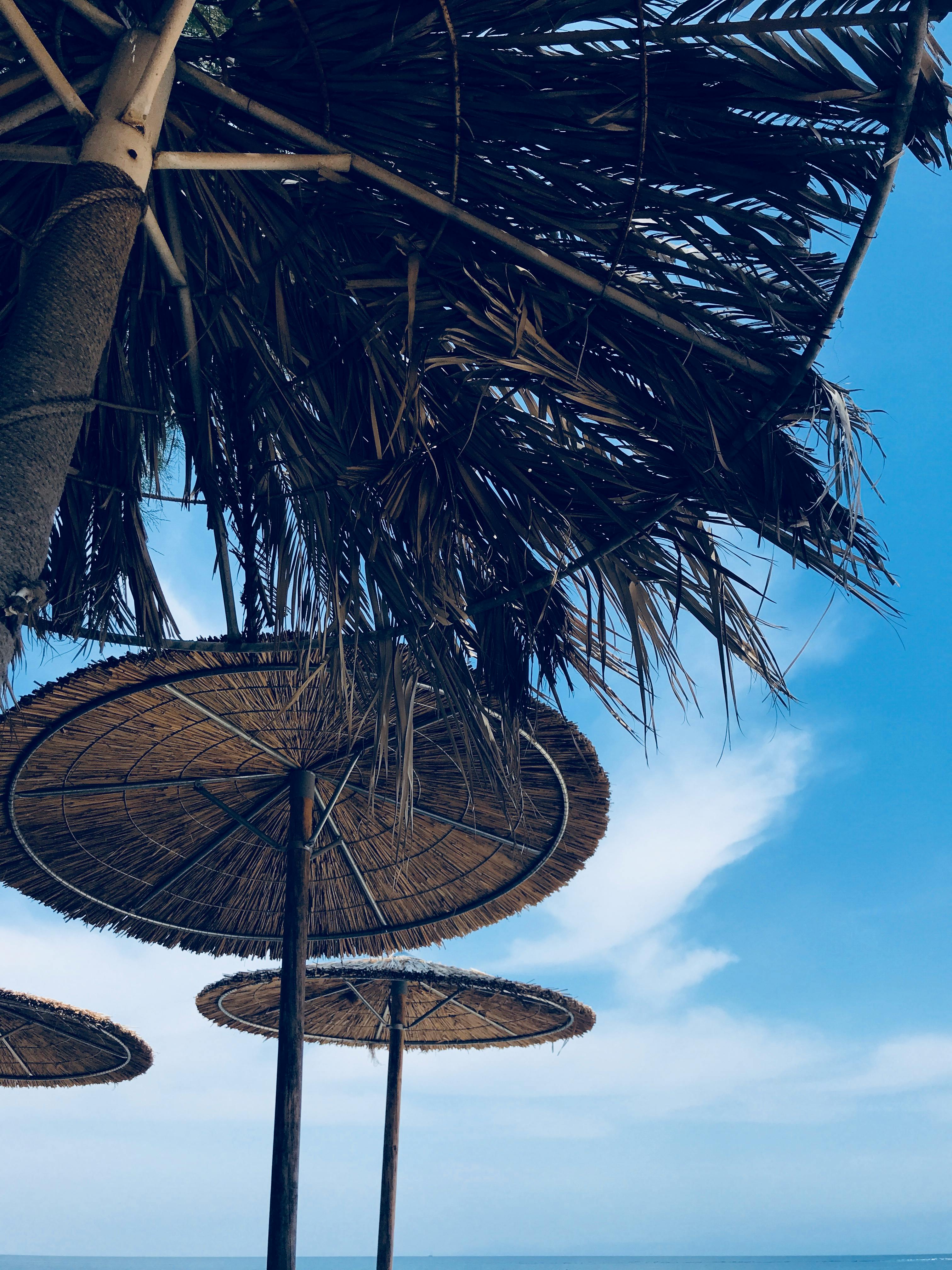 一个阳光明媚的日子里，人们在希腊斯卡拉马里恩海滩捕捉到了稻草伞