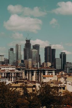 Distant view of urban skyscrapers under a cloudy sky, showcasing modern architecture.