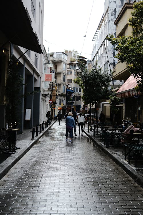 People on a Narrow City Street between Buildings 