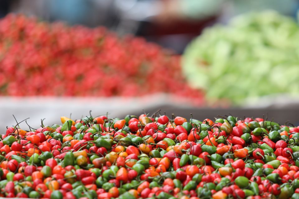 Heaps of small round red and green chillies on a seller's stall at a market in Kathmandu