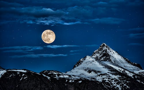 Scenic View of Snow Covered Mountains Against the Full Moon