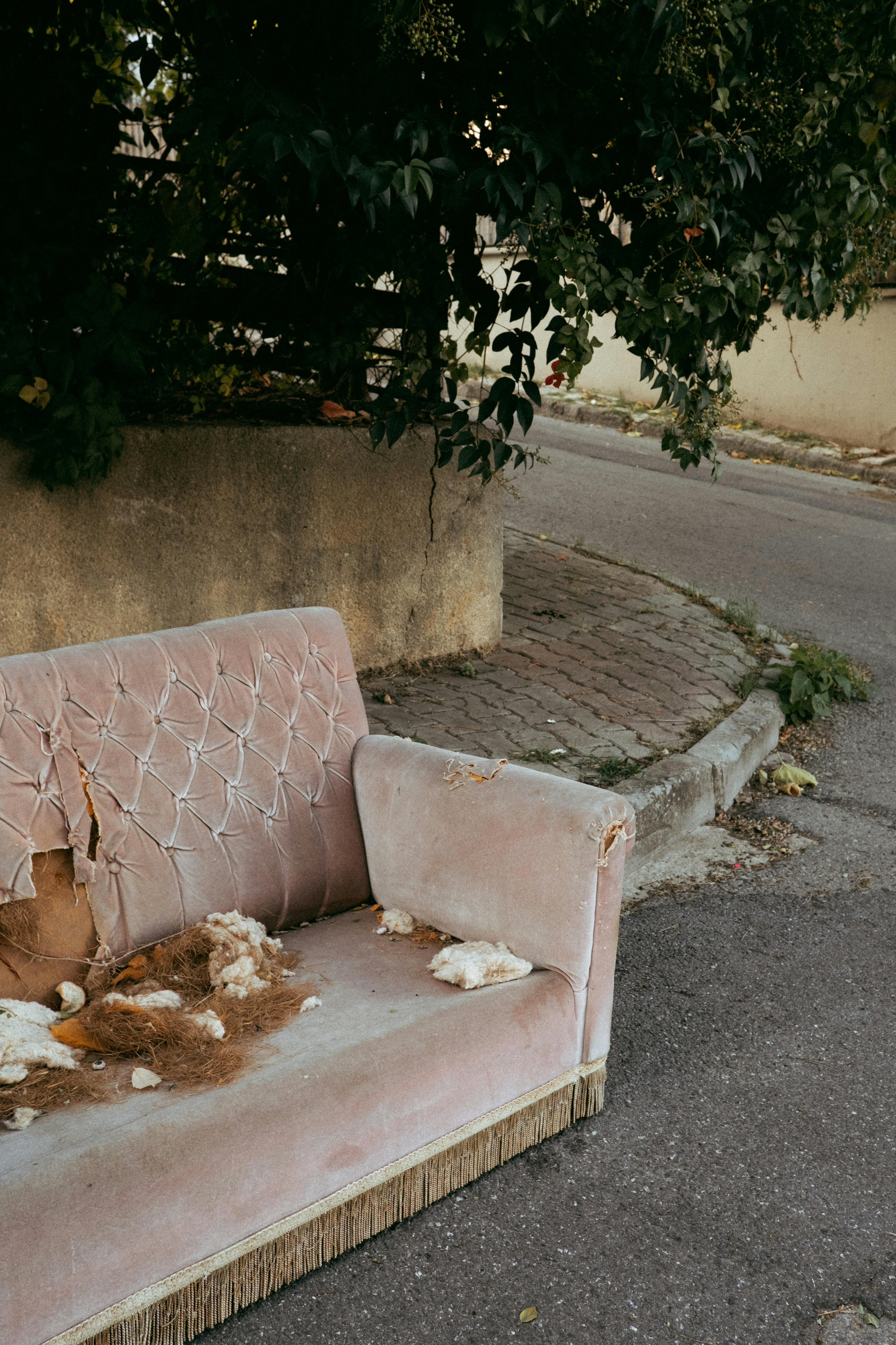 Free A worn-out sofa placed on a city street, reflecting urban decay. Stock Photo