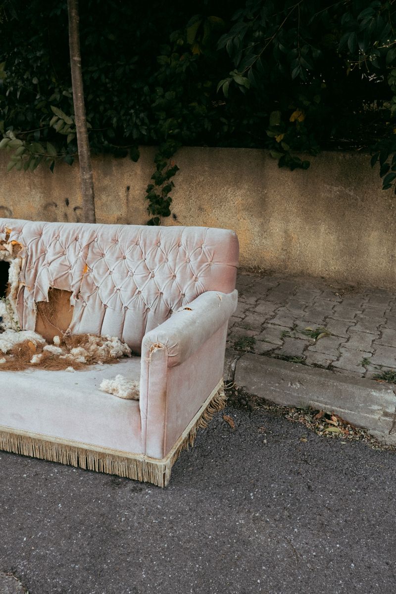 Residential junk removal — old sofa discarded on a curb outside a home in Pflugerville, TX