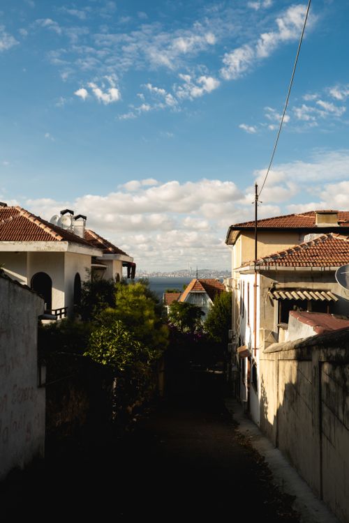 Free A peaceful narrow street in a vintage town with old buildings and a clear blue sky. Stock Photo