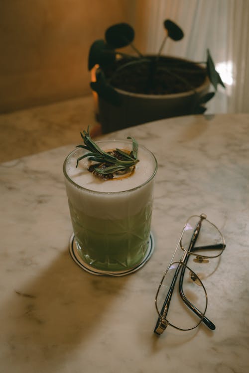 A Pair of Eyeglasses by a Matcha Latte Glass
