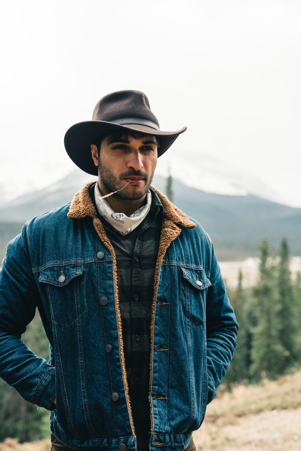 Man in a denim jacket wearing a cowboy hat