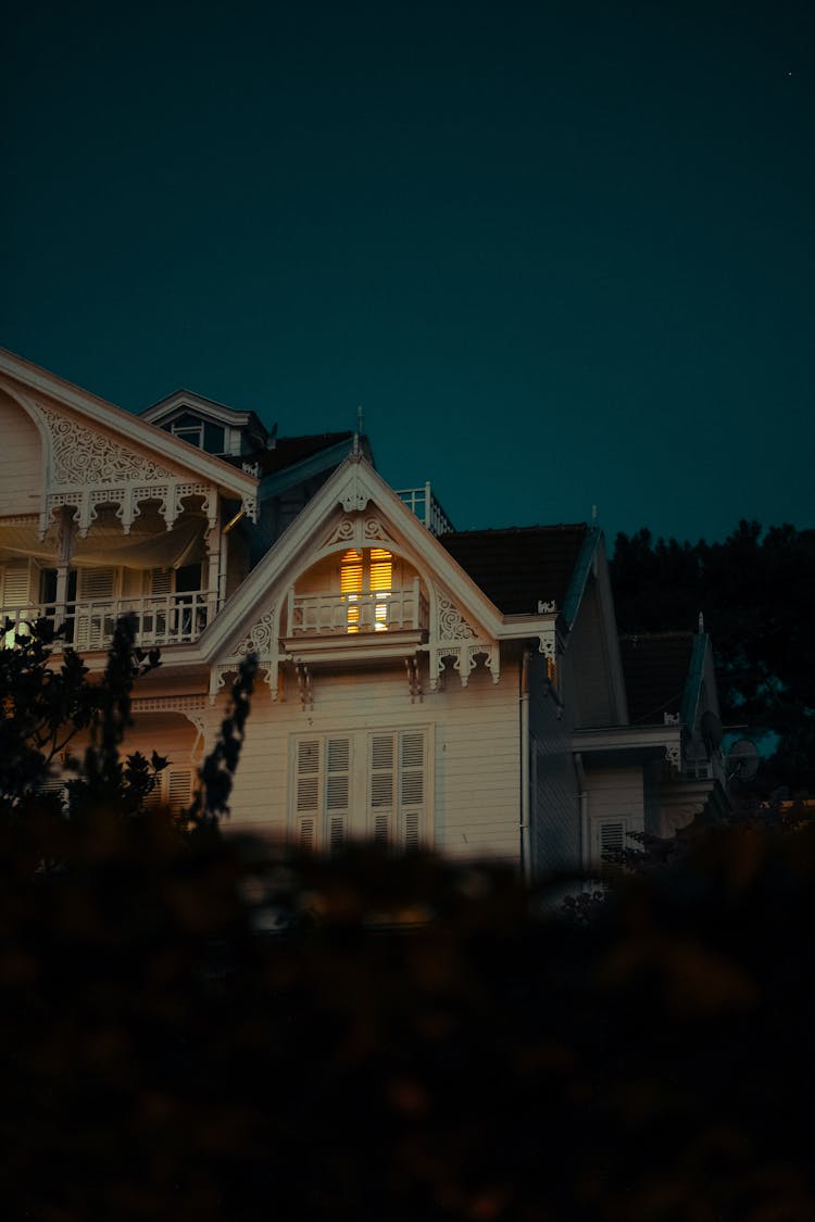 Light In Old House Against Dark Sky