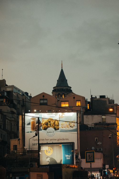 Free Evening view of Galata Tower in Istanbul with illuminated billboards and cityscape. Stock Photo