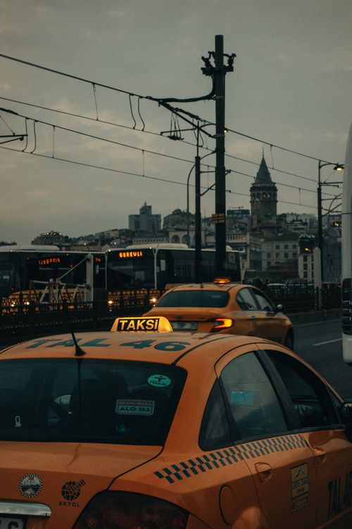Free Street view in Istanbul featuring a taxi and Galata Tower under evening light. Stock Photo