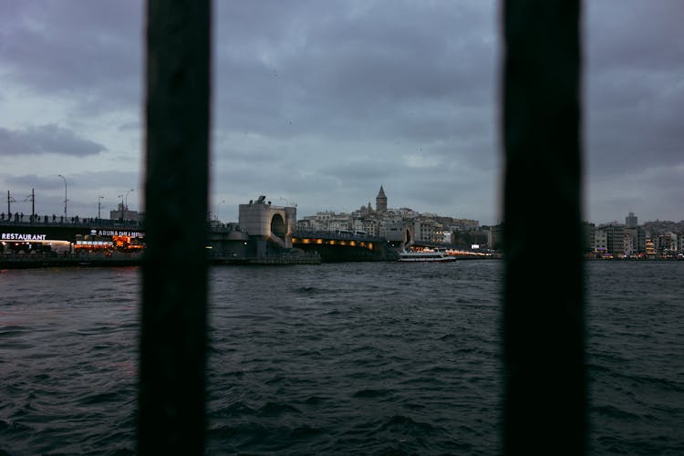 View Through Gates At Water And Bridge On Sunset